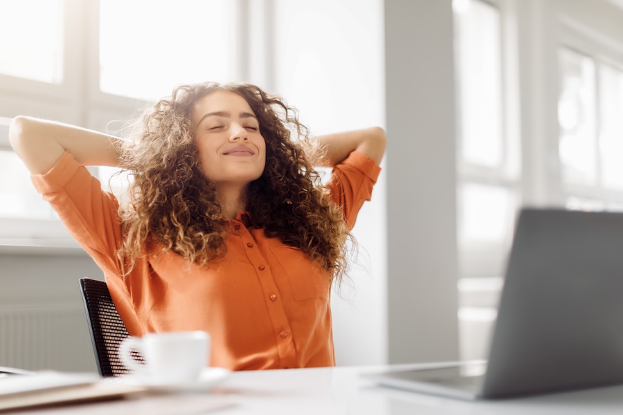 Personne travaillant dans un bureau lumineux et tempéré pendant une période de forte chaleur.